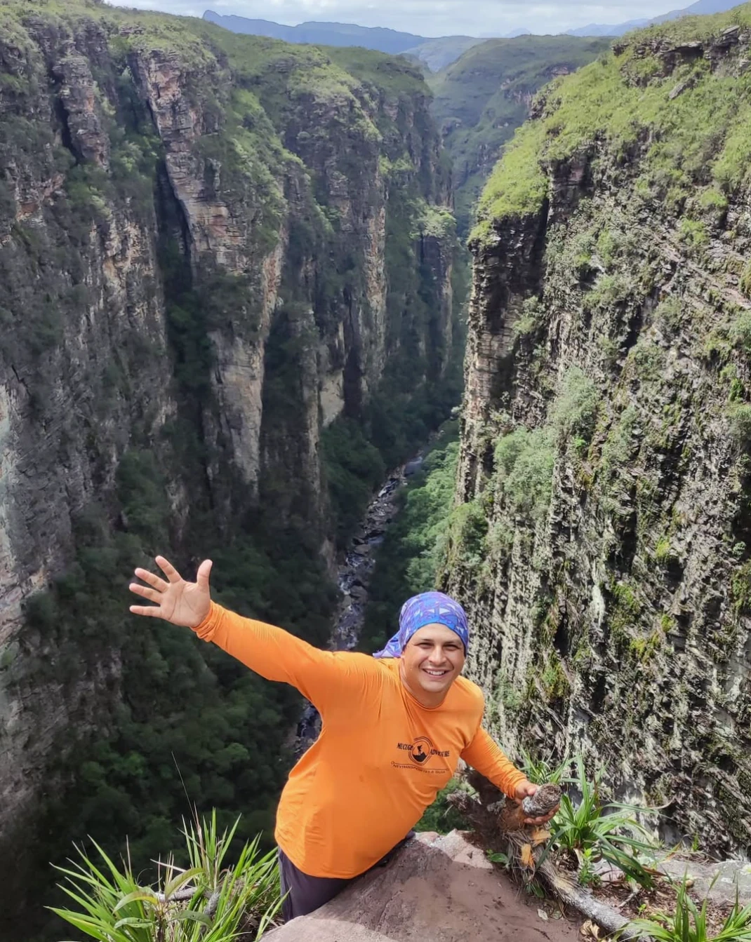 Ney de braços abertos à beira de um cânion da Chapada